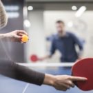 two-colleagues-playing-table-tennis-in-office-break-room-673117017-592611993df78cbe7e959740